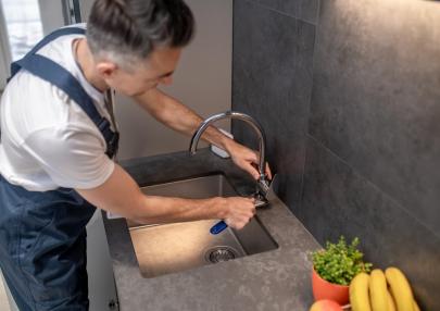 man-adjusting-water-tap-with-wrench_259150-58269