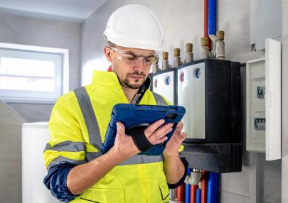 man-electrical-technician-working-switchboard-with-fuses-uses-tablet_169016-23926